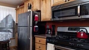 A kitchen with wooden cabinets, a stainless steel refrigerator, a microwave, a stove, and a coffee maker. - *BBQ *Pet Friendly *WIFI *Walk to Whiskey Row (Prescott)