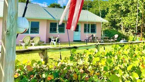 Ein Haus mit Veranda, einem Fahnenmast mit der US-amerikanischen Flagge und einem Garten im Vordergrund.