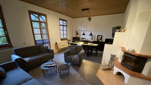 Un salón espacioso con chimenea, comedor y cocina al fondo.