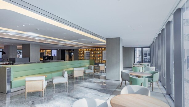 A modern hotel lobby with a reception desk, seating area, and a bar. - Ji Hotel (Taiyuan)