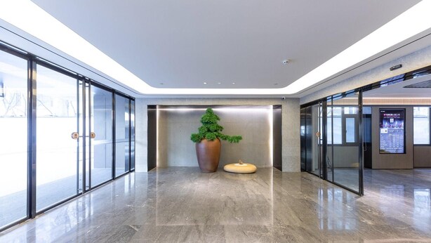 A modern lobby with glass doors, a large planter, and a digital information board. - Ji Hotel (Taiyuan)