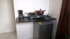 A compact kitchen with a gas stove, a coffee maker, and a small refrigerator. - ESTUDIO EN CARTAGENA CERCA AL MAR 202 (Cartagena)