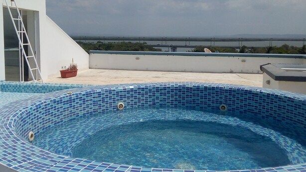 A rooftop swimming pool with blue mosaic tiles, a ladder, and a view of the sea. - apartment- suits 1 to 14 people (Cartagena)