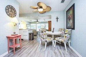 Enjoy meals at the round dining table with floral-patterned chairs in this open-plan living space.