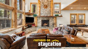 A spacious living room with a stone fireplace, leather sofas, and a pool table. - Snow Summit Bike Ski Estate | Family Friendly (Big Bear Lake)