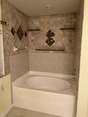 Bathtub, hair dryer, towels, toilet paper