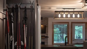 A kitchen with dark wooden cabinets, a built-in dishwasher, and a window with blinds.