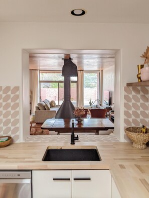 Enjoy a warm and inviting kitchen with a central island, sink, and dishwasher, offering a view of the outdoor area.