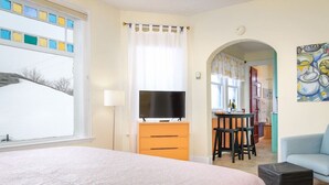 Une chambre à coucher avec un lit, une télévision, un bureau et une chaise.