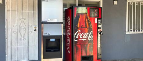 A vending machine with a Coca-Cola logo and a sign that says "Be Considerate. Please Do Not Fill Ice Chests."