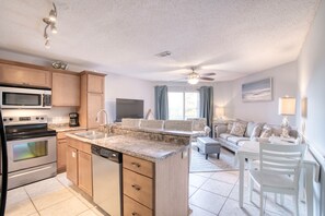 Enjoy a fully equipped kitchen with stainless steel appliances, a sofa set, and dining area.