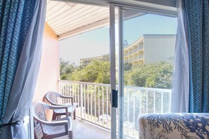 Relax on the balcony with a clear view of the surrounding buildings and foliage, perfect for casual dining or unwinding.