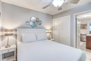 Relax in this serene bedroom with a large bed, bedside tables, and a decorative mirror wall.