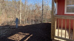 A wooden cabin with a red exterior and a wooden deck.
