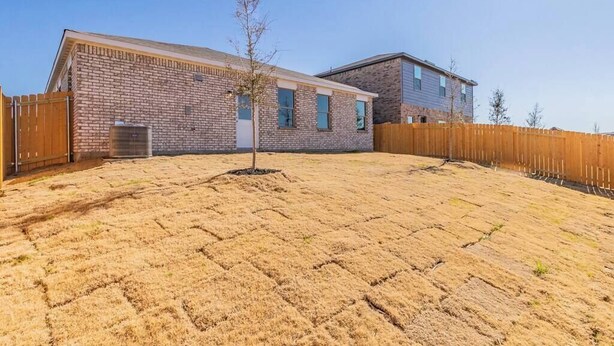 A residential area with a brick house, a wooden fence, and a dry lawn. - Modern Spacious 4BR New Built Retreat ~ Fam&Group (Seagoville)