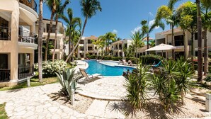 A resort with a central swimming pool surrounded by palm trees and lounge chairs. - Recently refurbished, five star facility (El Cortiesito-)