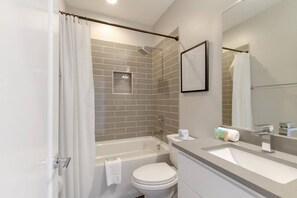 Un baño moderno con ducha, inodoro y lavabo.