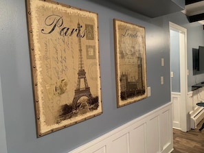 Iconic landmarks adorn the walls of this stylish room, featuring vintage-style artwork of the Eiffel Tower and the London Eye.