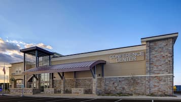 A conference center with a stone facade, a covered entrance, and an American flag.