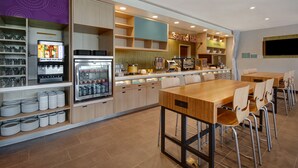 Un restaurant moderne doté d’un long comptoir, de plusieurs types de sièges et d’une variété de distributeurs de boissons et de plats.