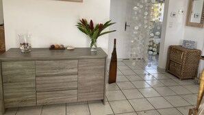 A modern living room with a wooden cabinet, a vase with flowers, and a decorative bottle.
