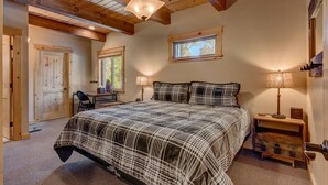 A bedroom with a large bed, two bedside lamps, a wooden desk, and a window. - Edelweiss - Remodeled Luxury 3 BR with Private Hot tub (Tahoe City)
