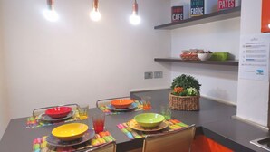 Een moderne keuken met een eettafel voor vier personen, voorzien van kleurrijke placemats en kommen.