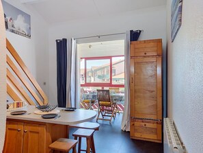 A kitchen with wooden cabinets, a dining table, and chairs. - Lovely apartment for 4 people with pool, WIFI and TV (Capbreton)