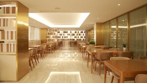 Una biblioteca moderna con estanterías, mesas y sillas de madera.