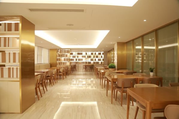 Una biblioteca moderna con estanterías, mesas y sillas de madera.