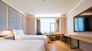 A hotel room with two beds, a desk, a television, and a window with curtains. - Ji Hotel (Taiyuan)