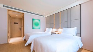 A hotel room with two beds, a large wall-mounted artwork, and a modern design. - Ji Hotel (Taiyuan)