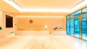 A modern hotel lobby with a reception desk, a large window, and a minimalist design. - Ji Hotel (Taiyuan)