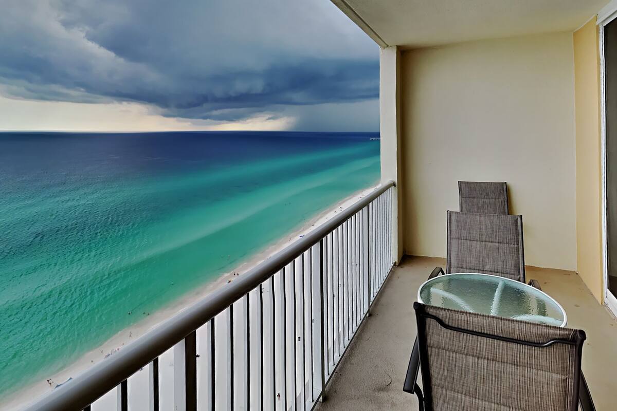 A balcony with a view of a beach and ocean.