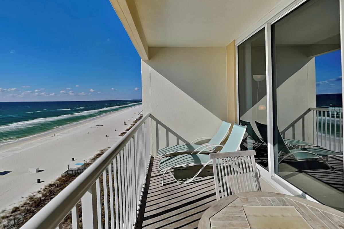 A balcony with a view of a beach and ocean.