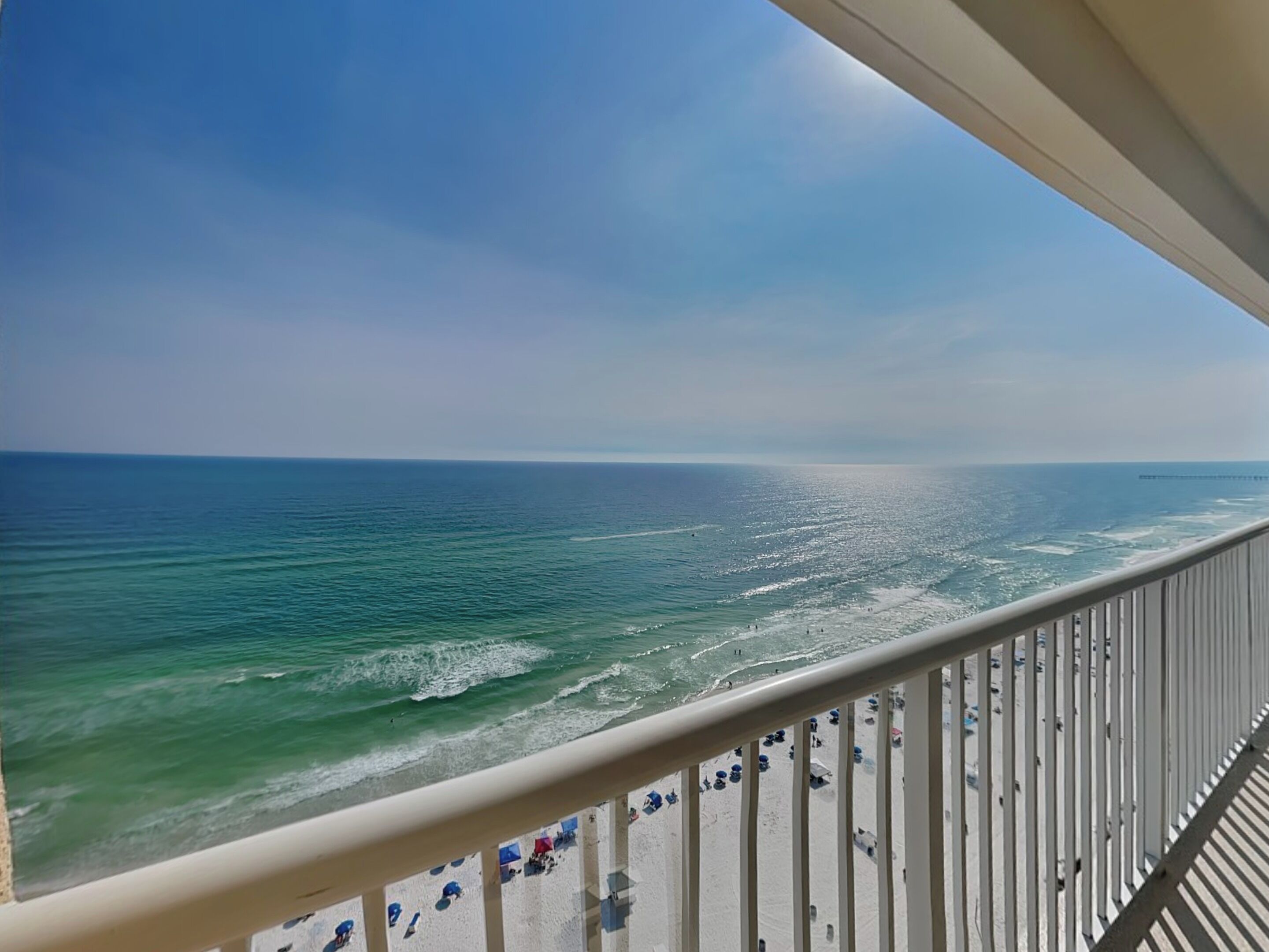 Uma varanda com vista para o oceano e a praia.