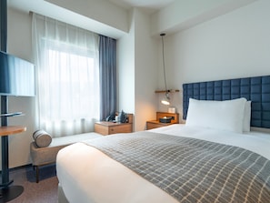 A hotel room with a large bed, bedside table, lamp, and a TV on a stand. - Hotel Resol Stay Akihabara (Tokyo)