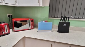 Une cuisine équipée d’un grille-pain, d’un four à micro-ondes, d’un bloc à couteaux et d’un trousseau de clés posé sur le comptoir.