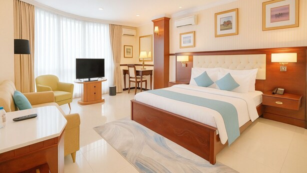 Ein Hotelzimmer mit einem großen Bett, einem Schreibtisch, einem Fernseher und einem Essbereich.