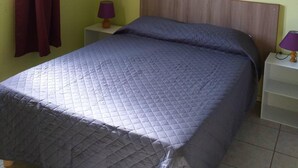 A bedroom with a bed, two nightstands, a window with curtains, and a headboard. - Les Océanides Villa 2 with sea view (Le Diamant)
