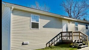 Uma casa térrea com varanda frontal e um pequeno deck.