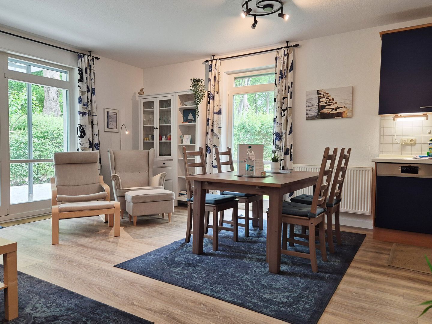 Een moderne woonkamer met een eettafel, stoelen, een bank en een kast.
