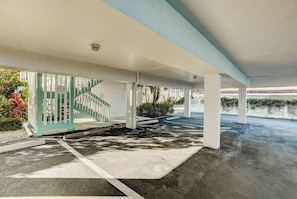 Uma área de estacionamento coberta com uma escadaria que leva à entrada de um edifício.