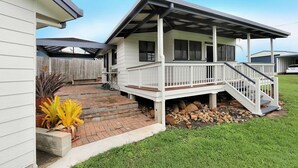A two-story house with a covered porch and a small deck.