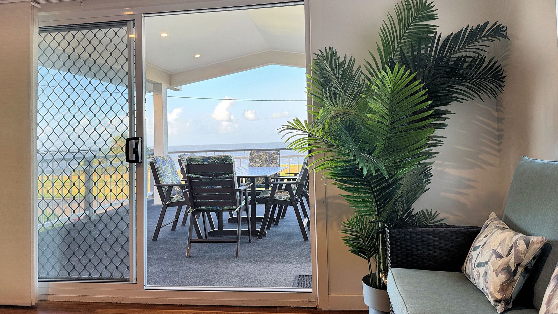 A room with a sliding glass door leading to an outdoor seating area with a table and chairs.