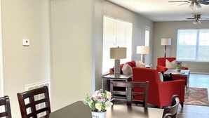 A dining area with a dark wooden table, red chairs, and a vase of flowers. - Huge Private 3 Bedroom House Large Master Fenced Yard, Galveston, Kemah, Fishing (Texas City)