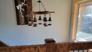 Un escalier en bois avec une rampe, un luminaire suspendu et une œuvre d’art fixée au mur.