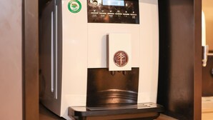 A coffee machine with a digital display and a logo on the top. - Ji Hotel Shanghai People's Square Beijing West Roa (Shanghai)