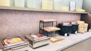 A buffet setup with various food containers, a display of baked goods, and a coffee station. - Ji Hotel Shanghai People's Square Beijing West Roa (Shanghai)