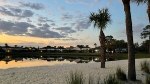 A beach with sand, a calm water body reflecting the sky, and palm trees. - Relaxing 4BR + 3Bath Villa Sleeps 10, with FREE heated pool!  (Kissimmee)